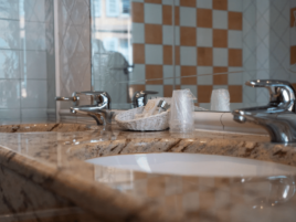 Salle de bain équipée d’une double vasque en marbre avec produits d’accueil, Hôtel Saint Martin au cœur du centre historique de Colmar.