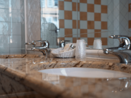 Salle de bain équipée d’une double vasque en marbre avec produits d’accueil, Hôtel Saint Martin au cœur du centre historique de Colmar.